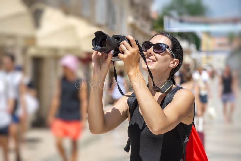 Toerist met een camera die de straten op een zonnige dag fotograferen royalty-vrije stock afbeelding Toerist met een camera die de straten op een zonnige dag fotograferen royalty-vrije stock afbeelding