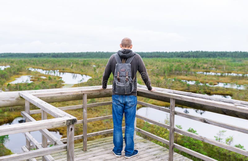 Toerist op brug met rugzak wordt tegengehouden om van aard in de zomerdag te genieten die stock afbeeldingen Toerist op brug met rugzak wordt tegengehouden om van aard in de zomerdag te genieten die stock afbeeldingen