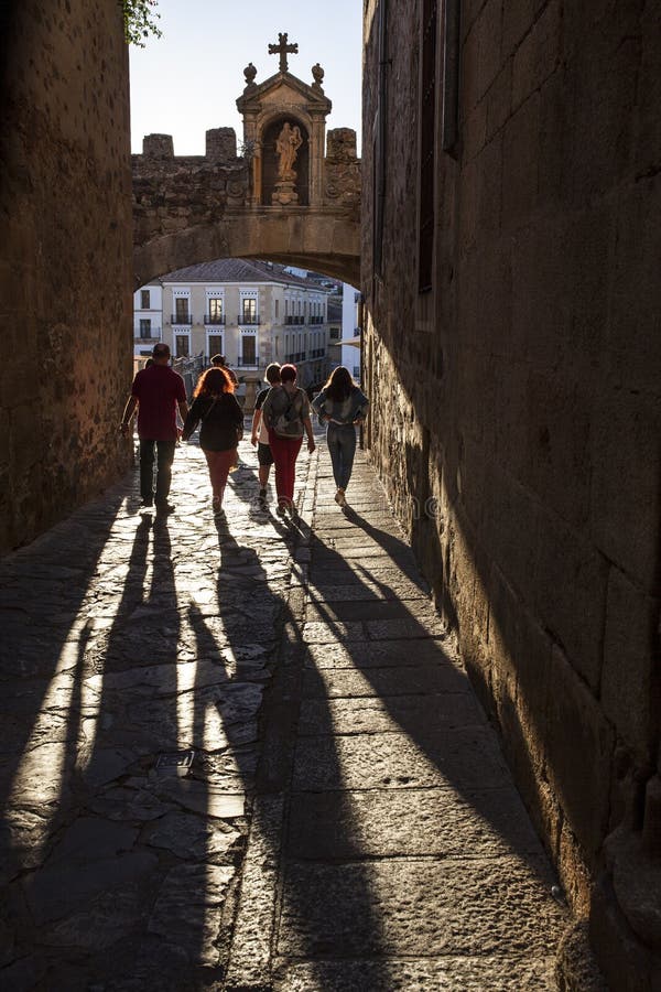 Toeristen die onder Sterboog of Arco DE La Estrella, Caceres lopen stock foto Toeristen die onder Sterboog of Arco DE La Estrella, Caceres lopen stock foto