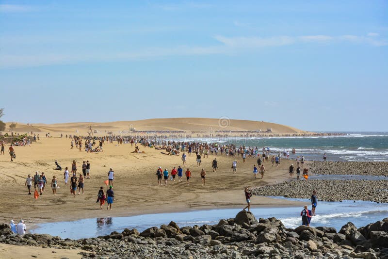 Toeristen die op een strand het eiland op van Gran Canaria (Grote Kanarie) lopen, tussen Maspalomas en Playa del Ingles stock afbeelding Toeristen die op een strand het eiland op van Gran Canaria (Grote Kanarie) lopen, tussen Maspalomas en Playa del Ingles stock afbeelding