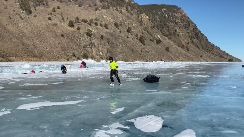 Toeristen reizen op schaatsen op het ijs van het diepgevroren meer baikal.