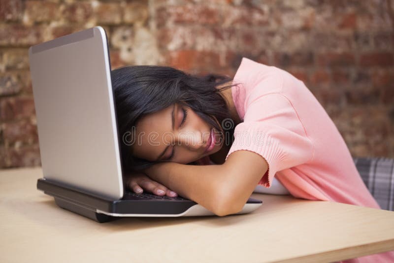 Toevallige onderneemsterslaap bij haar bureau op haar laptop royalty-vrije stock afbeelding Toevallige onderneemsterslaap bij haar bureau op haar laptop royalty-vrije stock afbeelding