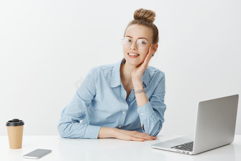 Toevallige werkdag in bureau Portret die van positieve knappe onderneemster in glazen, dichtbij laptop smartphone zitten royalty-vrije stock fotografie Toevallige werkdag in bureau Portret die van positieve knappe onderneemster in glazen, dichtbij laptop smartphone zitten royalty-vrije stock fotografie