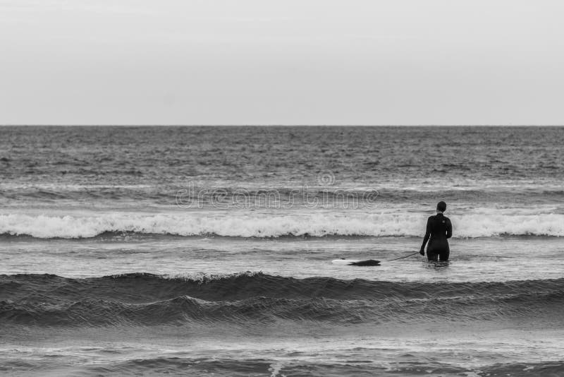 TOFINO, CANADA - 2 septembre 2018 : cavalier de surfer ou de vague tenant la planche de surf sur le fond de l'océan photo stock TOFINO, CANADA - 2 septembre 2018 : cavalier de surfer ou de vague tenant la planche de surf sur le fond de l'océan photo stock