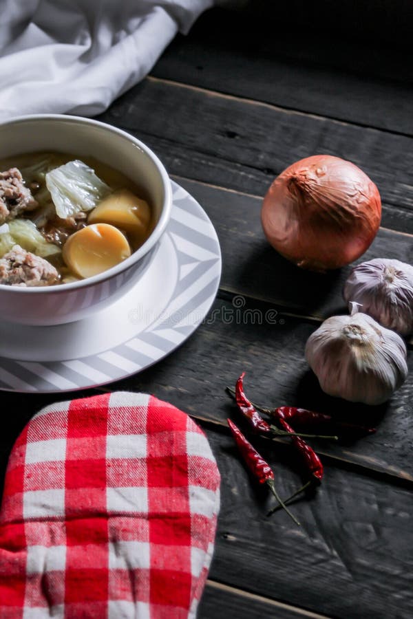 Tofu bouilli et porc haché servi dans des tasses blanches servies sur une table en bois noir en asie