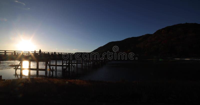 A dawn of Togetsukyo bridge near Katsuragawa river in Kyoto in autumn wide shot