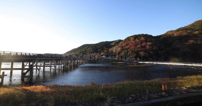 A dawn of Togetsukyo bridge near Katsuragawa river in Kyoto in autumn wide shot panning