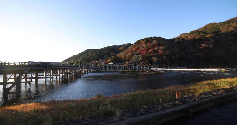 A dawn of Togetsukyo bridge near Katsuragawa river in Kyoto in autumn wide shot panning