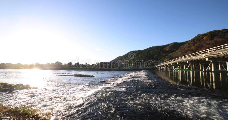 A dawn of Togetsukyo bridge near Katsuragawa river in Kyoto in autumn wide shot