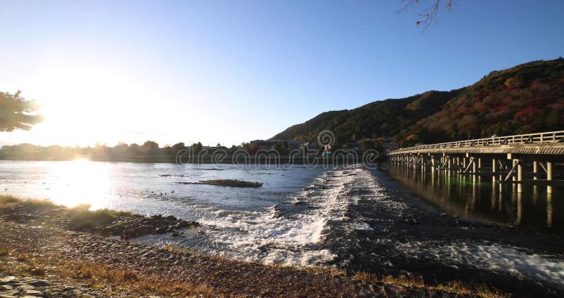 A dawn of Togetsukyo bridge near Katsuragawa river in Kyoto in autumn wide shot panning