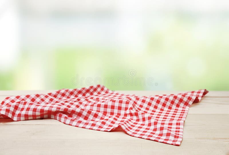 Red picnic cloth towel on wooden table natural blurred background,product display,food advertisement design.Gingham napkin. Red picnic cloth towel on wooden table natural blurred background,product display,food advertisement design.Gingham napkin