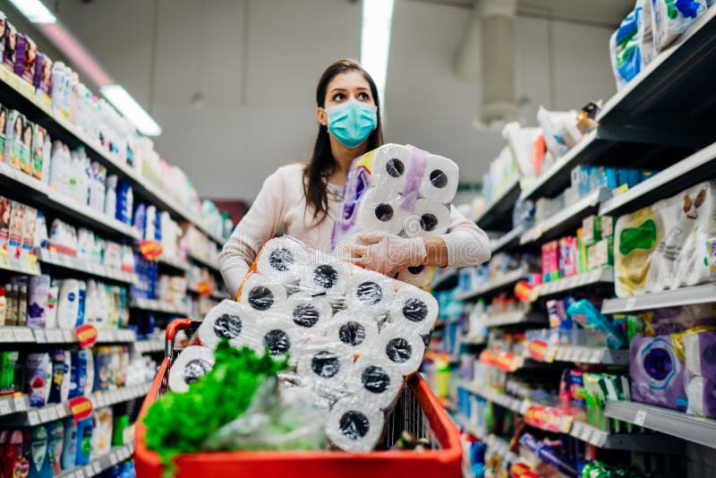 Toilette paper shortage.Woman with hygienic mask shopping for toilette paper supplies due to panic buying and product hoarding during virus epidemic outbreak.Hygiene products deficiency. Toilette paper shortage.Woman with hygienic mask shopping for toilette paper supplies due to panic buying and product hoarding during virus epidemic outbreak.Hygiene products deficiency