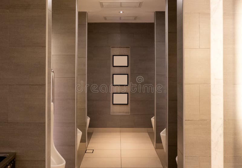 Toilette publique brune de luxe avec l'urinoir en céramique de rangées images libres de droits Toilette publique brune de luxe avec l'urinoir en céramique de rangées images libres de droits