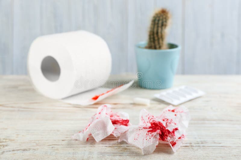 Toilettenpapier mit Blut auf weißem Tisch Hämorrhoiden.