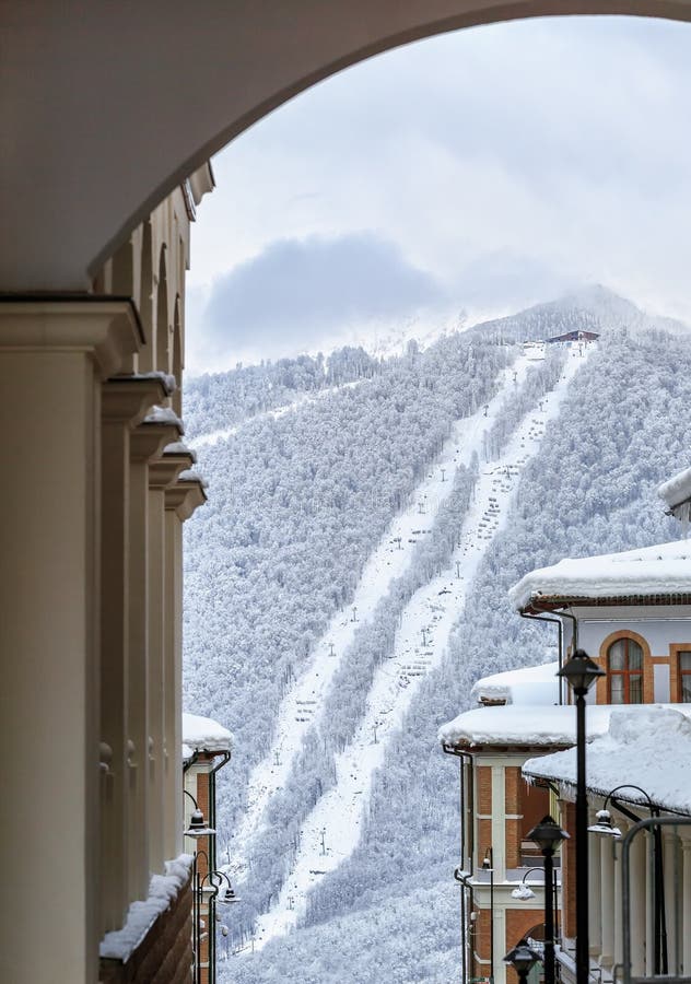 Toits d'hôtel de Milou de station de sports d'hiver de montagne d'hiver de Gorki Gorod sur la pente de ski et le fond neigeux de images stock Toits d'hôtel de Milou de station de sports d'hiver de montagne d'hiver de Gorki Gorod sur la pente de ski et le fond neigeux de images stock