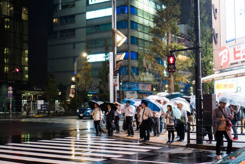 Tokio, Japón - 5 de octubre de 2018: los hombres de negocios y las mujeres abrieron sus paraguas como la lluvia vierte en la noch imágenes de archivo libres de regalías Tokio, Japón - 5 de octubre de 2018: los hombres de negocios y las mujeres abrieron sus paraguas como la lluvia vierte en la noch imágenes de archivo libres de regalías