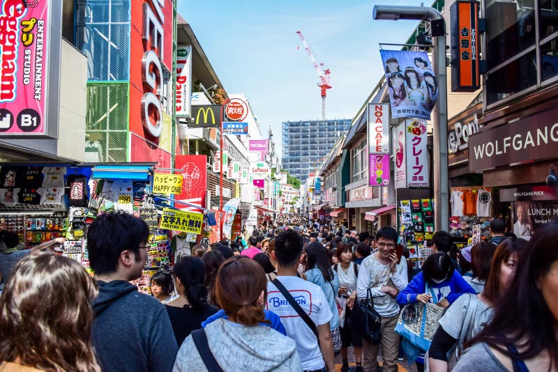 TOKYO, GIAPPONE - MAGGIO 2016: La gente sta comperando alla via di Takeshita, una strada dei negozi famosa allineata con i boutiq fotografia stock TOKYO, GIAPPONE - MAGGIO 2016: La gente sta comperando alla via di Takeshita, una strada dei negozi famosa allineata con i boutiq fotografia stock