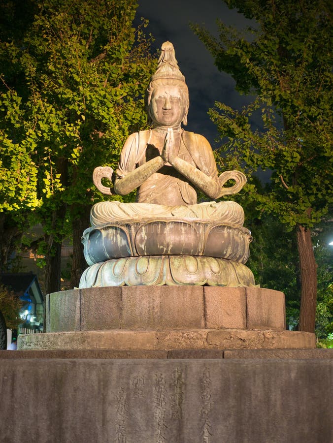 Tokyo, Japan. September 8, 2018�. Gray stone Buddha statue in meditation at night stock photography Tokyo, Japan. September 8, 2018�. Gray stone Buddha statue in meditation at night stock photography