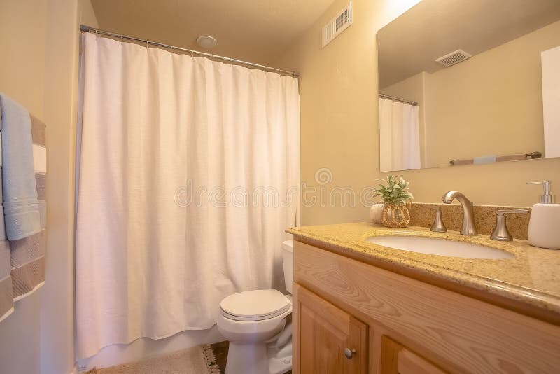 Toliet y área de la vanidad dentro de un cuarto de baño con la barra y el espejo de la toalla en la pared foto de archivo Toliet y área de la vanidad dentro de un cuarto de baño con la barra y el espejo de la toalla en la pared foto de archivo