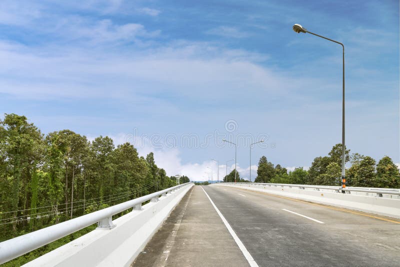 Tom huvudvägväg för skönhet med lampstolpen och träd på dagbakgrund för blå himmel royaltyfri fotografi Tom huvudvägväg för skönhet med lampstolpen och träd på dagbakgrund för blå himmel royaltyfri fotografi