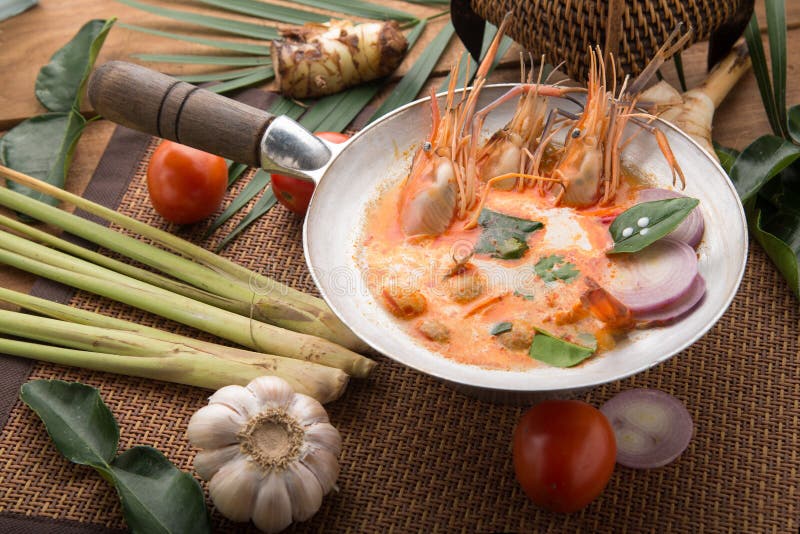 Tom yam kong or Tom yum, Tom yam is a spicy clear soup typical in Thailand Cuisine. Tom yam kong on wooden table. Thai food stock images Tom yam kong or Tom yum, Tom yam is a spicy clear soup typical in Thailand Cuisine. Tom yam kong on wooden table. Thai food stock images