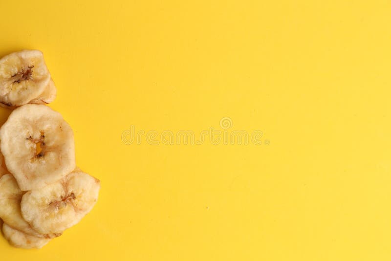 Toma de gran angular de un montón de plátanos secos aislados en una superficie amarilla fotografía de archivo libre de regalías