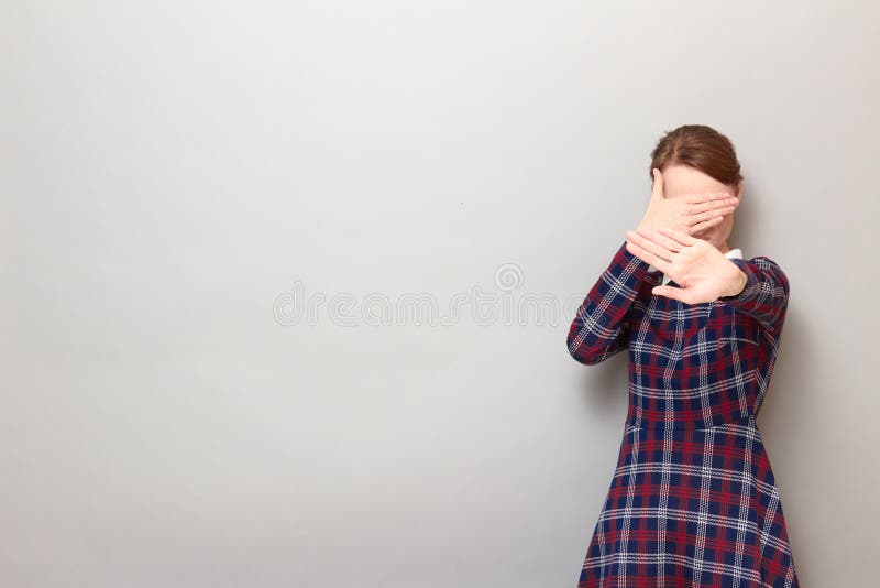 Toma de una niña disgustada cubriendo su cara estirando la palma a la cámara