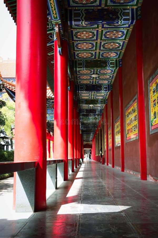 Una toma vertical de la entrada de un templo budista con columnas rojas
