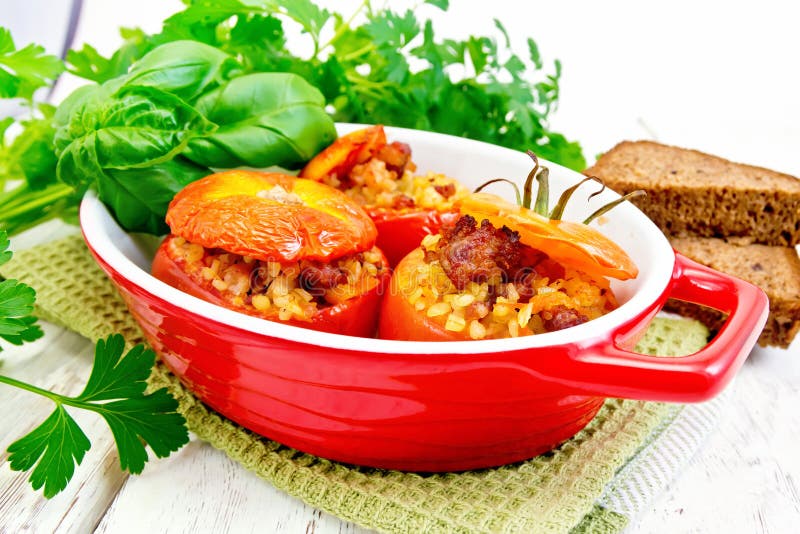 Tomaten angefüllt mit Bulgur in der Wanne auf hellem Brett stockbilder Tomaten angefüllt mit Bulgur in der Wanne auf hellem Brett stockbilder