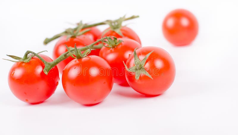 Tomates de cereja no branco do ramo imagens de stock royalty free Tomates de cereja no branco do ramo imagens de stock royalty free