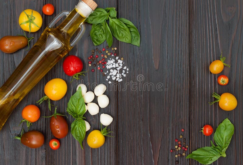 Tomates de cereza, mozzarella, hojas de la albahaca, especias y aceite de oliva desde arriba Ingredientes caprese italianos de la imágenes de archivo libres de regalías Tomates de cereza, mozzarella, hojas de la albahaca, especias y aceite de oliva desde arriba Ingredientes caprese italianos de la imágenes de archivo libres de regalías