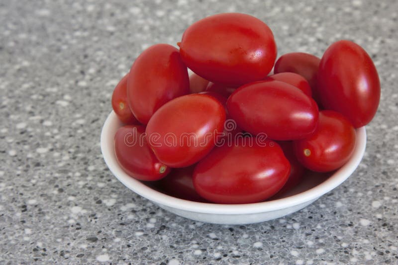 Tomates de prune de bébé dans une cuvette en forme de coeur photos libres de droits Tomates de prune de bébé dans une cuvette en forme de coeur photos libres de droits