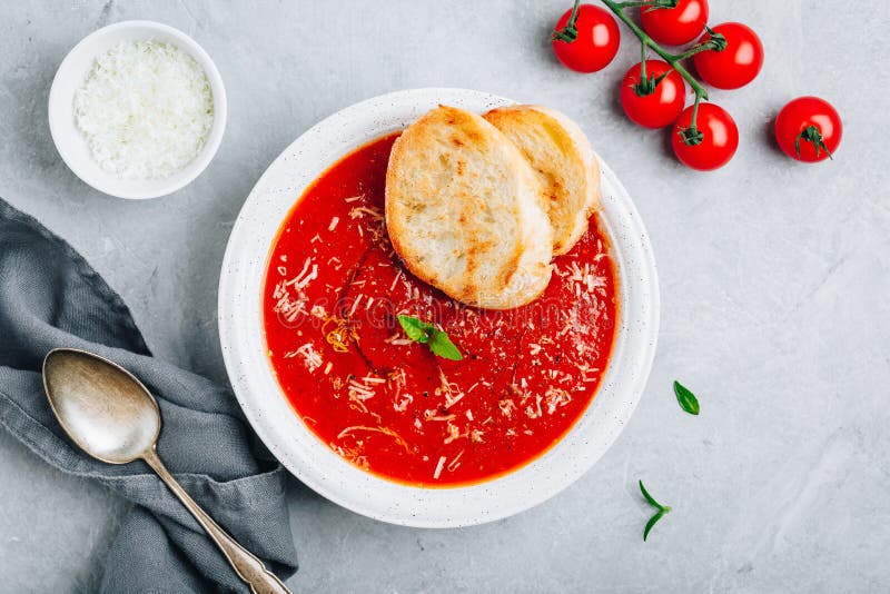 Tomato Basil Soup with Parmesan Cheese and Bread Toasts on Gray Stone