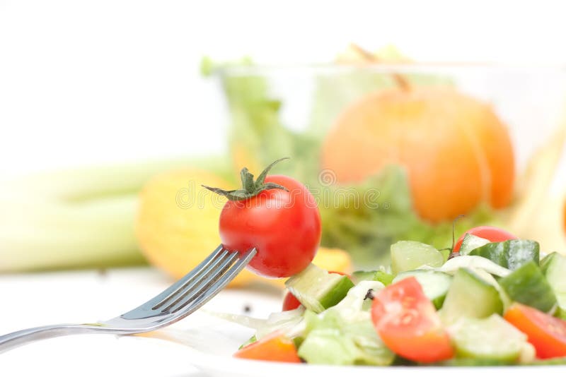 Tomato cherry on a fork. Diet