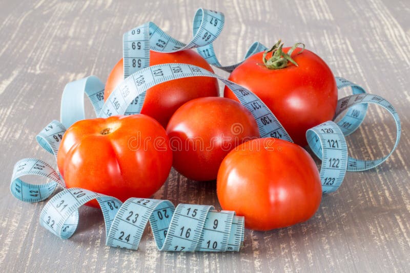 Tomato fruits and tape measure.