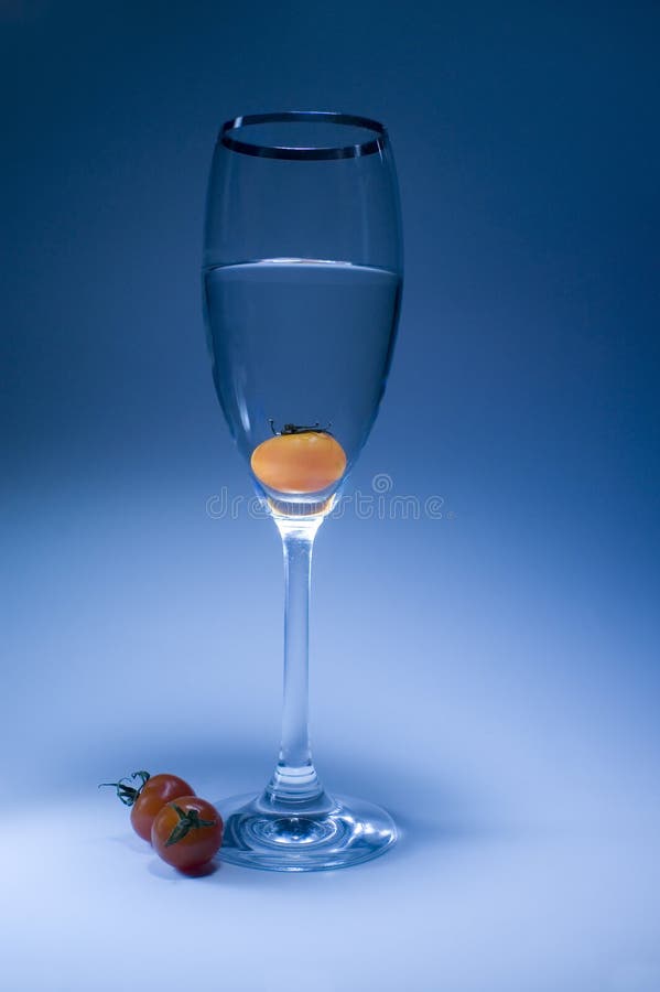 Tomato in the glass in light blue background