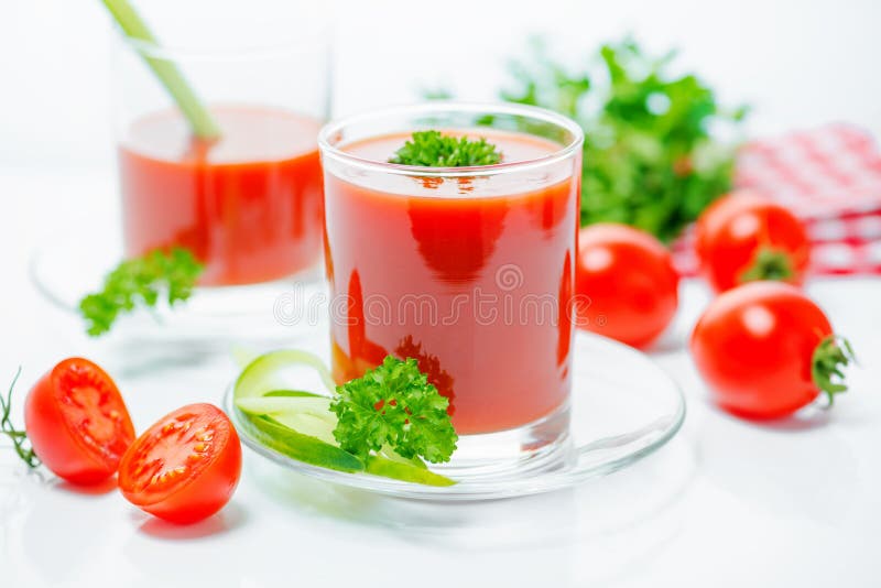 Tomato juice in transparent glasses with parsley, cutted tomato