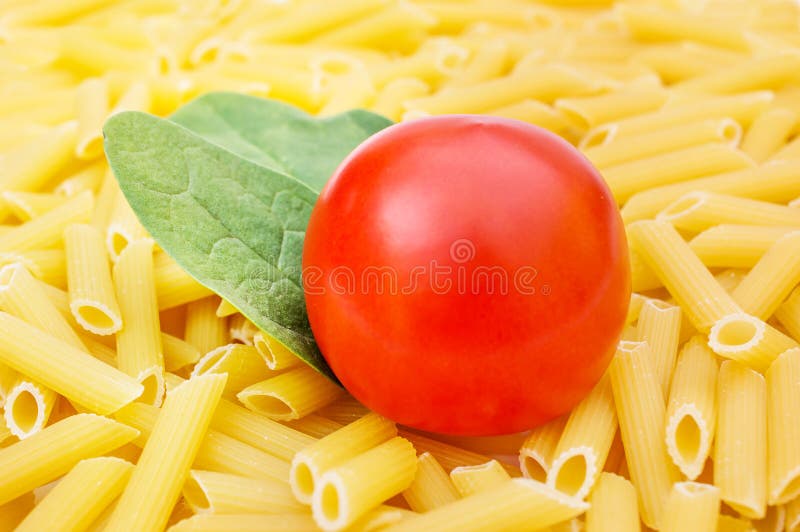 Tomato with Leaves of Spinach on Raw Pasta. Cooking Food Stock Image