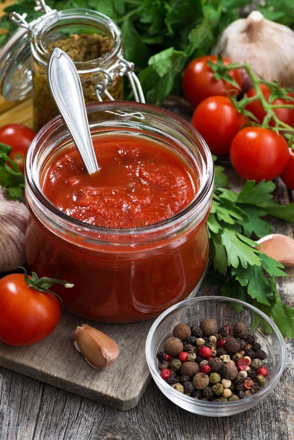 Tomato Sauce in a Glass Jar and Ingredients, Vertical Stock Photo