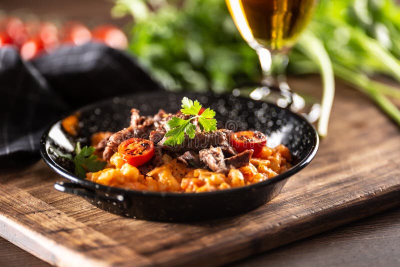 Tomato sauce gnocchi with sous-vide beef and fresh tomatoes served in a dark plate