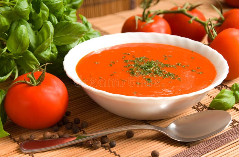 Tomaten Suppe in eine Schüssel mit frischen und gesunden Zutaten und Kräutern.