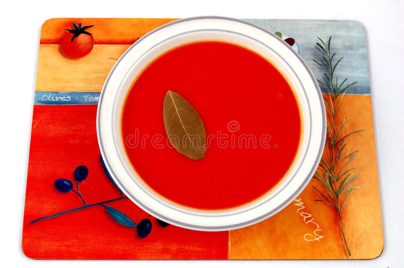 Tomato Soup and a Bay Leaf on a Colourful Table Mat. Stock Image