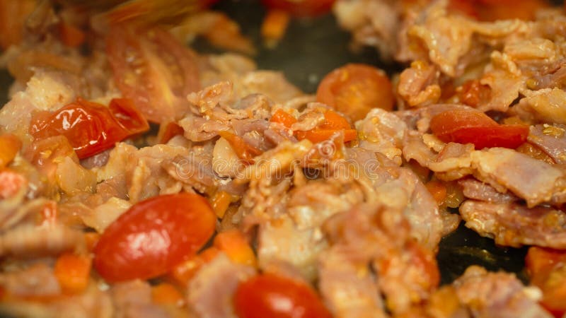 Tomatoes bacon onion carrots in a pan stock photos