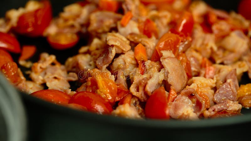Tomatoes bacon onion carrots in a pan stock image