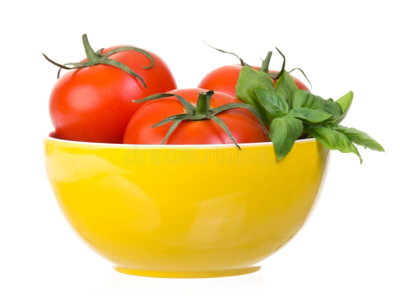 Tomatoes and basil in yellow bowl isolated