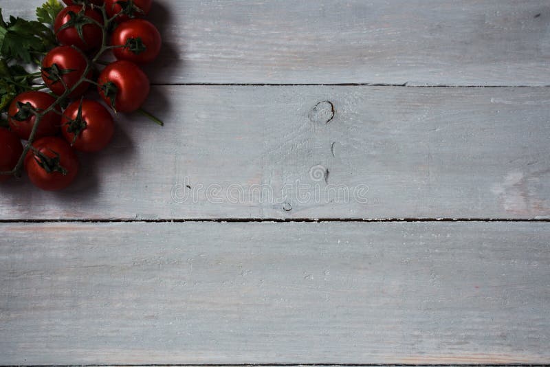 Tomatoes with greens on wooden background stock photo Tomatoes with greens on wooden background stock photo