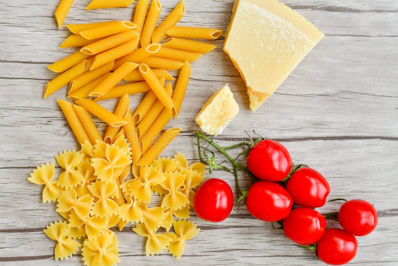 Tomatoes, mozzarella, raw pasta, parmesan cheese and green basil leaves royalty free stock photography Tomatoes, mozzarella, raw pasta, parmesan cheese and green basil leaves royalty free stock photography