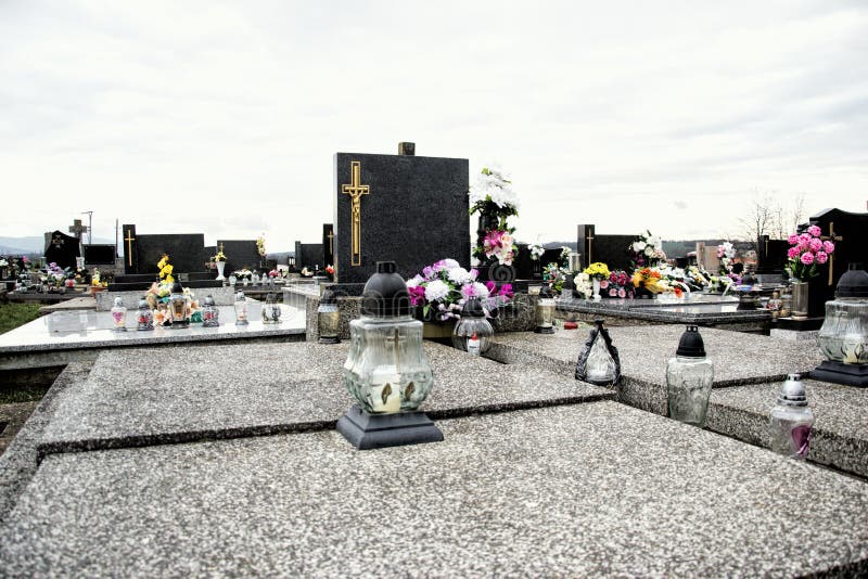 Tombes, pierres tombales et crucifix sur le cimetière traditionnel Bougies votives de lanterne et fleurs sur des pierres de tombe photo stock Tombes, pierres tombales et crucifix sur le cimetière traditionnel Bougies votives de lanterne et fleurs sur des pierres de tombe photo stock