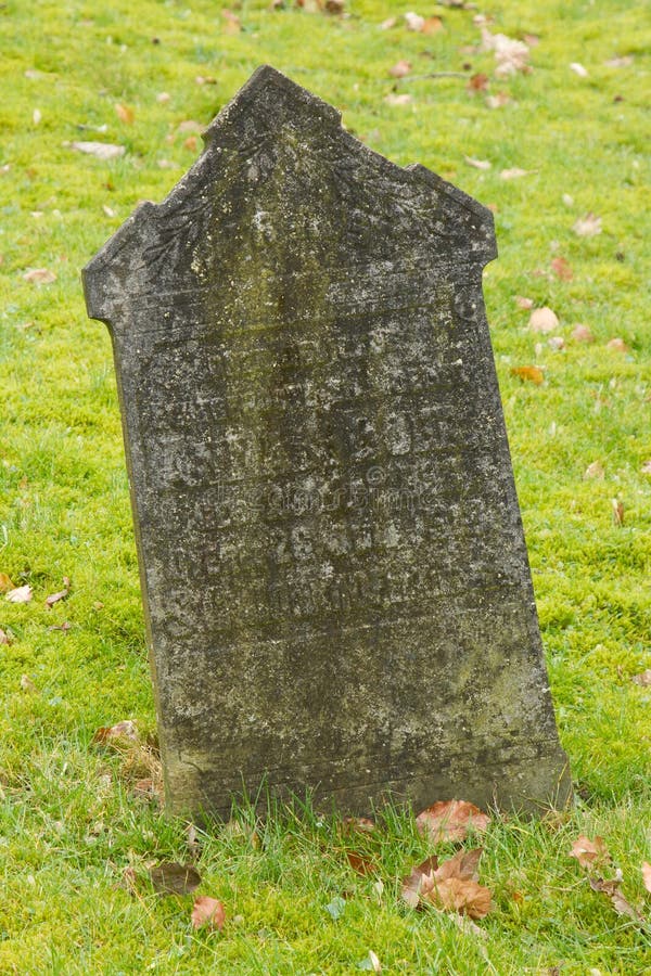 A tombstone on an old graveyard