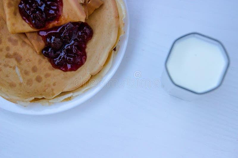 Tome o café da manhã para crianças, panquecas com leite e doce imagens de stock royalty free Tome o café da manhã para crianças, panquecas com leite e doce imagens de stock royalty free